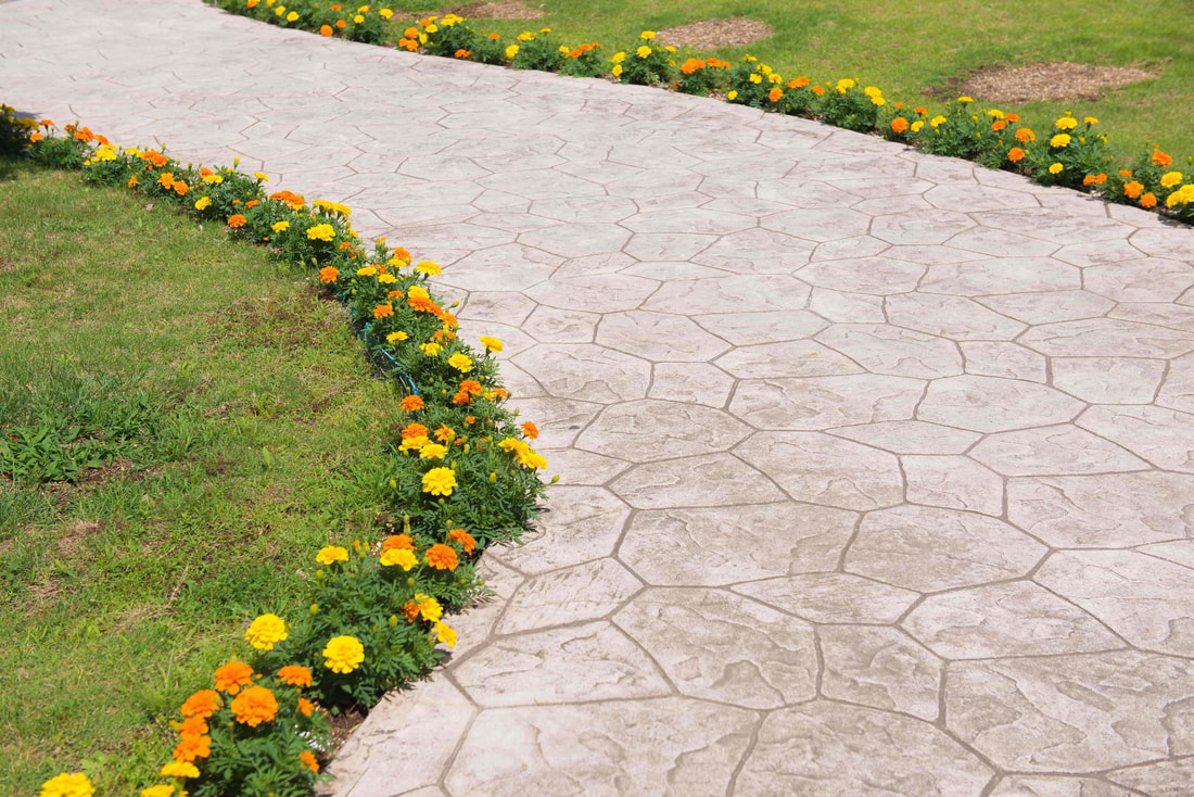 A stamped concrete pathway was installed in a municipal park in Abbotsford. The pathway is outline by pretty flowers.