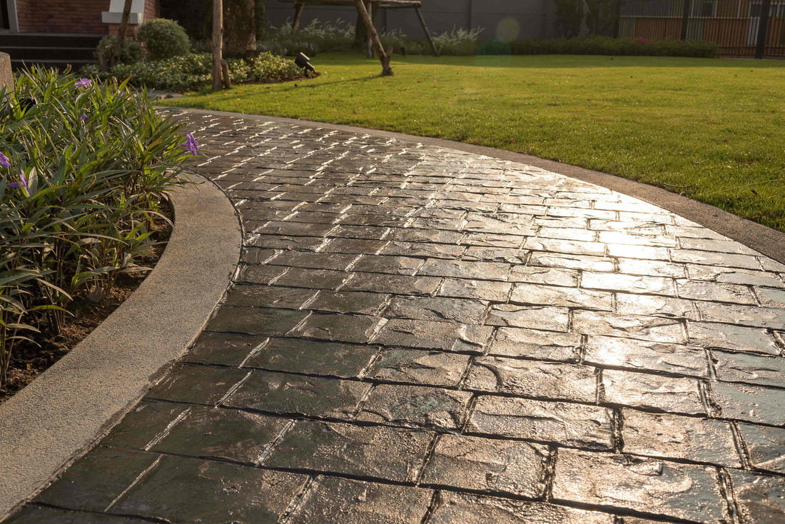 This is a photo of a stamped concrete pathway that goes through the backyard of a luxury home in Abbotsford.
